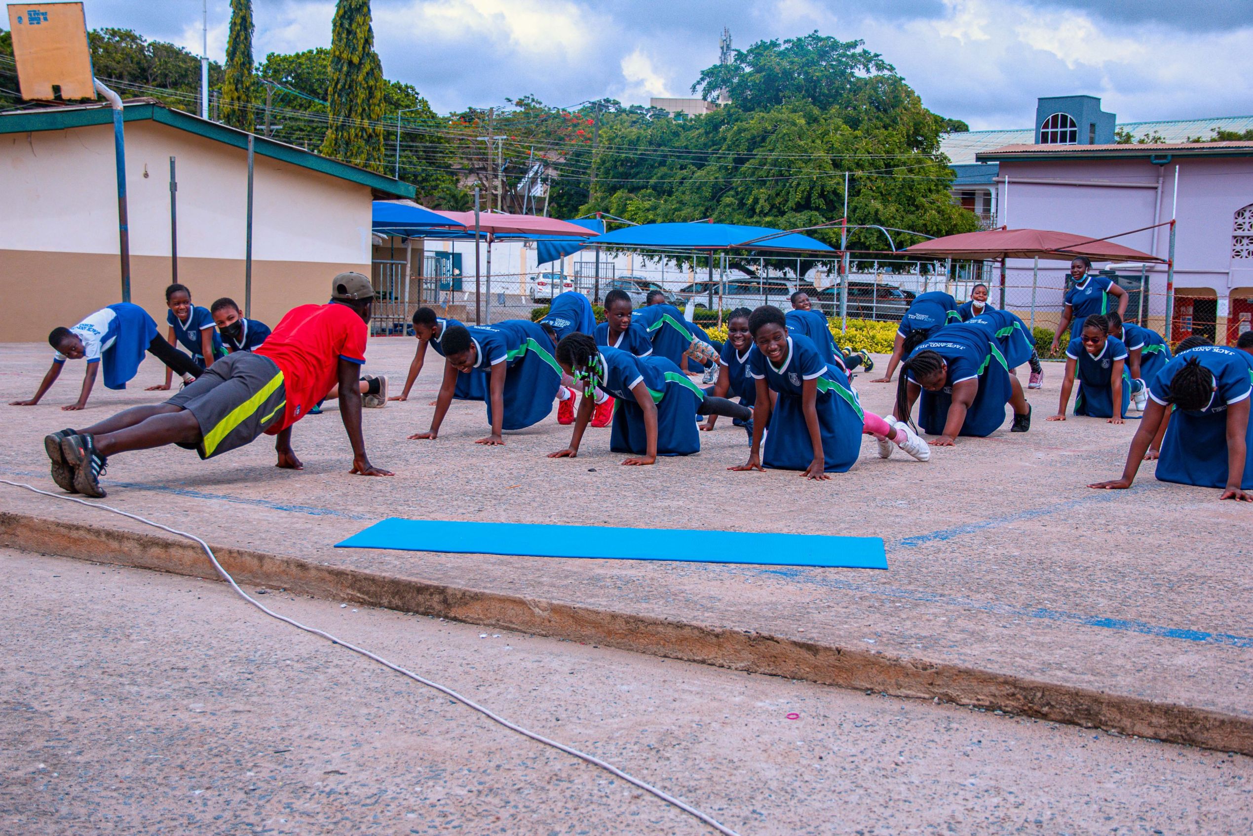 Girls in PE kit doing exercises with their coach