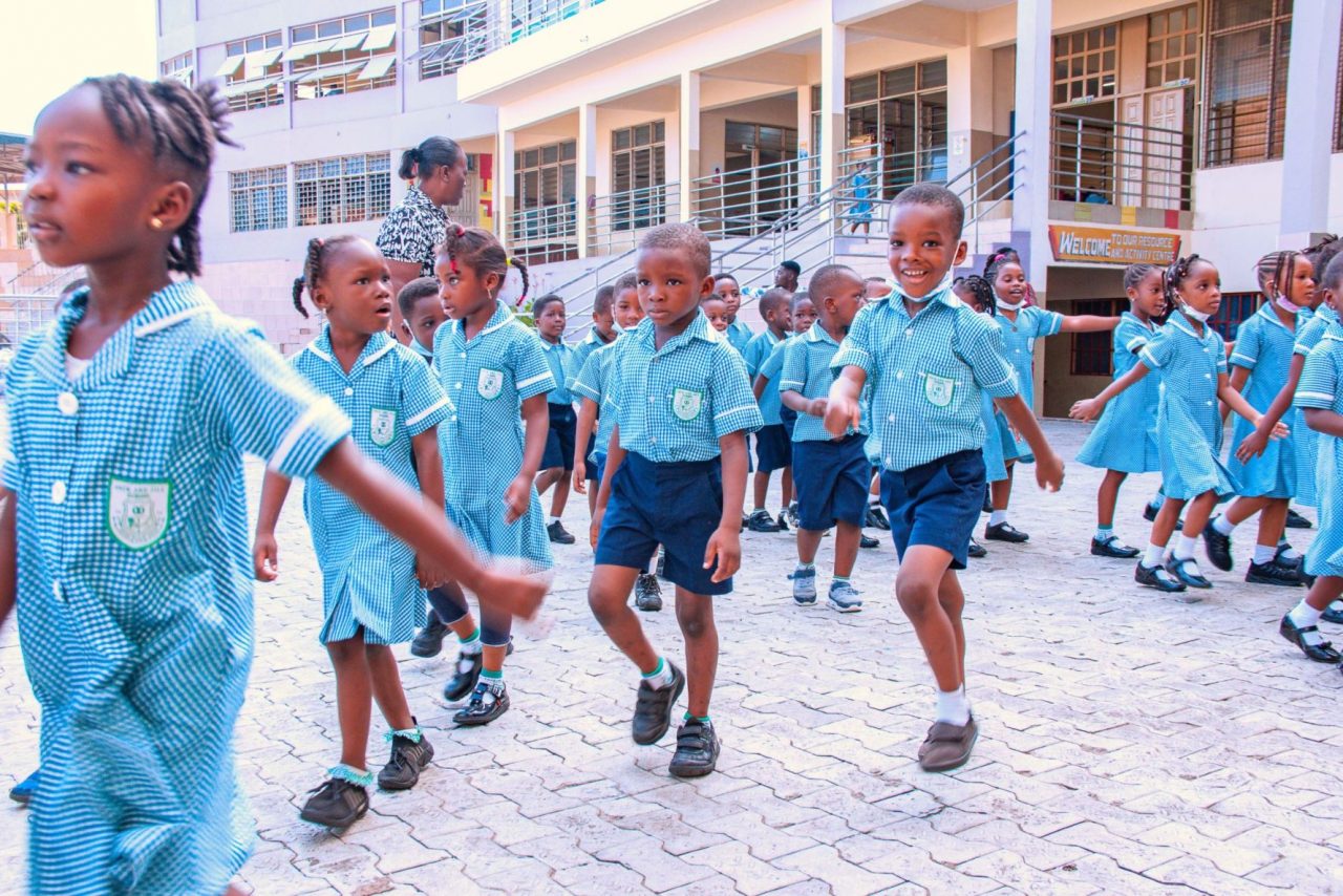 Pupils in blue gingham marching together in the courtyard
