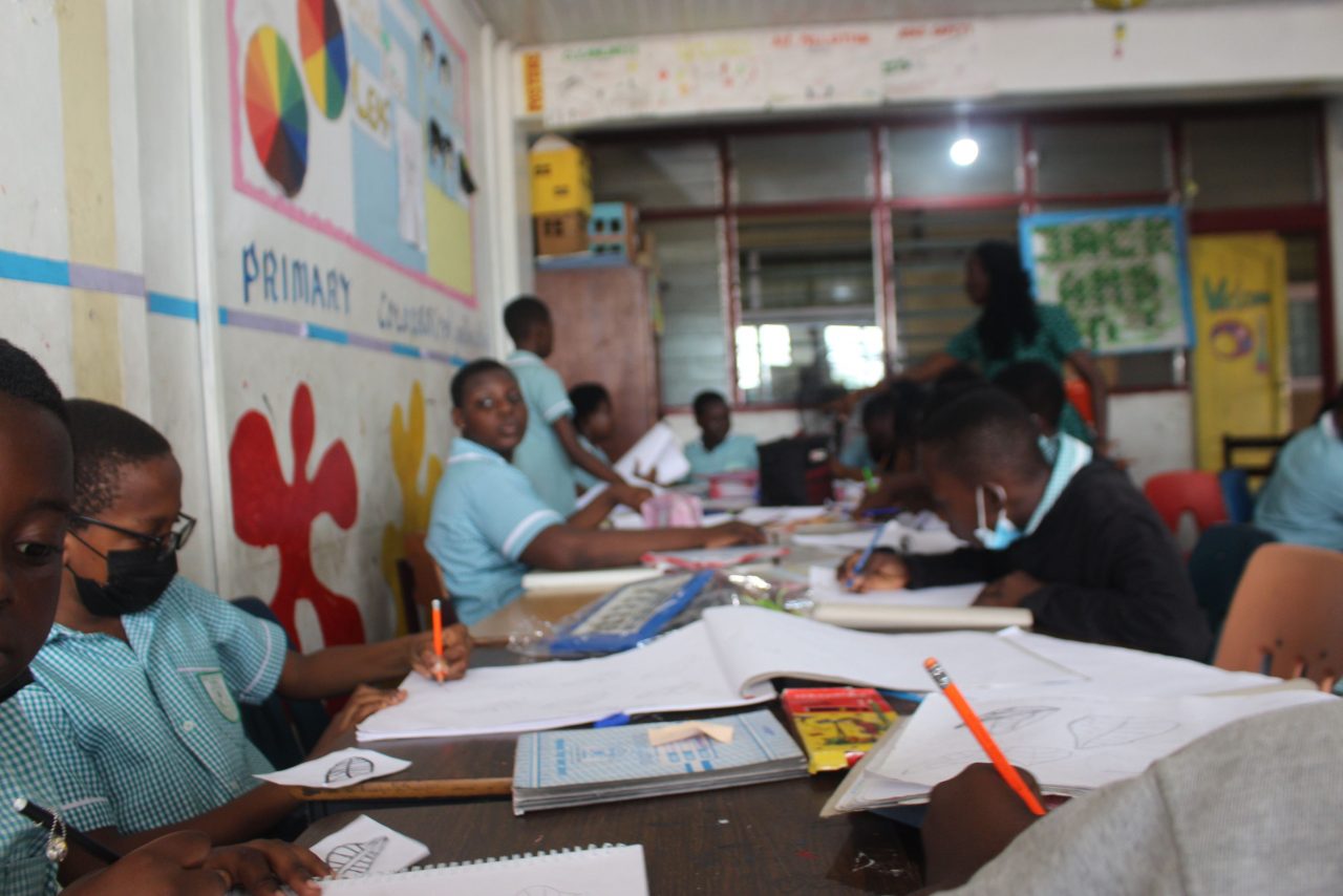 Primary pupils drawing and writing in class
